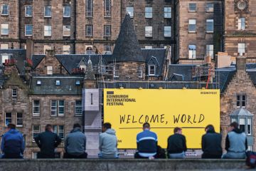 EDINBURGH, SCOTLAND - AUGUST 14: Citizen stand in front of the welcome sign of Edinburgh Festival Fringe on August 14, 2016 in Edinburgh, Scotland. EDINBURGH, SCOTLAND - AUGUST 14: Citizen stand in front of the welcome sign of Edinburgh Festival Fringe on August 14, 2016 in Edinburgh, Scotland.