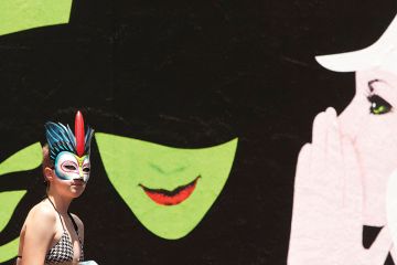 Woman passes Wicked billboard Woman passes Wicked billboard