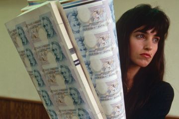 Woman holding sheets of uncut £5 banknotes, Bank of England printing works Woman holding sheets of uncut £5 banknotes, Bank of England printing works