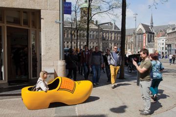 Woman sitting in giant yellow clog Woman sitting in giant yellow clog