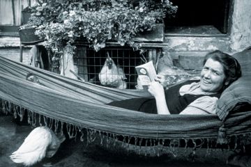Woman lying in hammock reading book Woman lying in hammock reading book