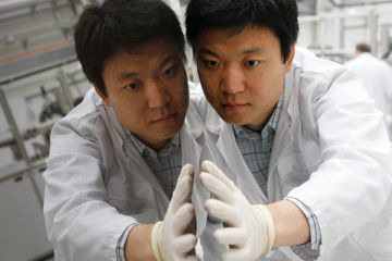 Worker checks thin-film silicon solar module, Truebbach