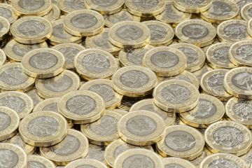 Wrexham, UK - April 10, 2017 Hoard of money. Lots of coins scattered in a large pile. New British pound coins introduced in 2017