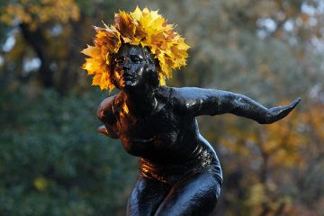 A statue with a crown of yellow leaves