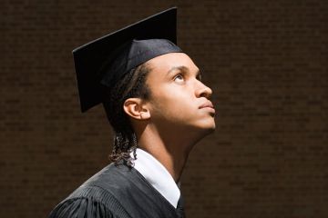 Young male student in graduation cap and gown Young male student in graduation cap and gown