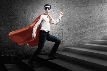 Young man standing on stairs dressed as superhero