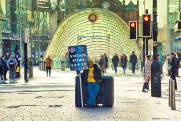 Young person holding a sandwich board advert, Glasgow. To illustrate that most students are employed in low-paid jobs. 