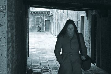 Young woman walking through archway, Venice, Italy Young woman walking through archway, Venice, Italy