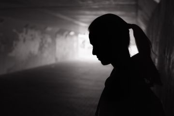 Young female standing in a dark tunnel