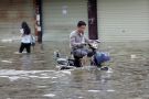 Man riding a bicycle in flood Man riding a bicycle in flood