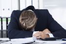 Overworked man slumped on desk