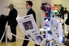 A robot holds a newspaper during a demonstration at the World Economic Forum (WEF) annual meeting in Davos
