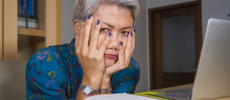 A woman reading a book with her head in her hands