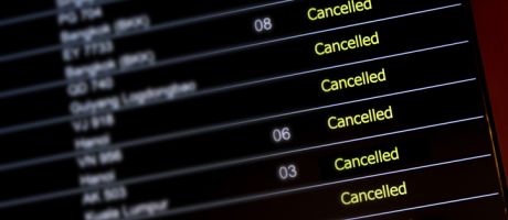 An airport departure board with lots of flights cancelled illustrating an opinion article about cancel culture