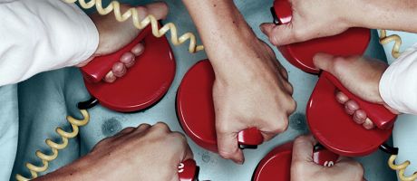 Several hands holding defibrillators on a chest. To illustrate that while there is a flow of extra medical graduates, the health system in the UK lacks the resources to boost training places or offer permanent jobs.