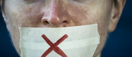 A woman with tape over her mouth symbolising free speech