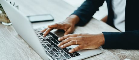 An unrecognisable person using a laptop in an office 
