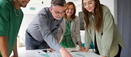 A businessman points at a chart while brainstorming with colleagues, symbolising green business expertise A businessman points at a chart while brainstorming with colleagues, symbolising green business expertise