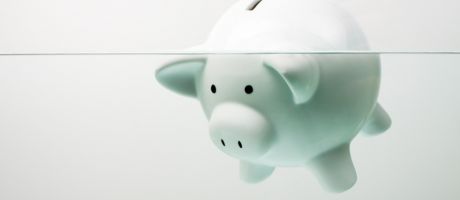 Piggy bank drowning in debt