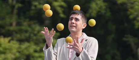 Man juggling several balls, illustrating the struggle to balance the competing pressures of teaching and studying for PhD studentships.