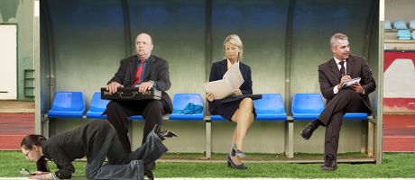 People in suits sitting on a soccer substitute bench. To illustrate that Skills England has no clear role in forming or implementing policy.