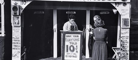 Historical photo of a fortune teller's booth, the Temple of Knowledge, showing advertising posters, admission taker, and two women customers waiting their turns. To illustrate that admissions on predicted A-level grades look foolish in AI era. Historical photo of a fortune teller's booth, the Temple of Knowledge, showing advertising posters, admission taker, and two women customers waiting their turns. To illustrate that admissions on predicted A-level grades look foolish in AI era.