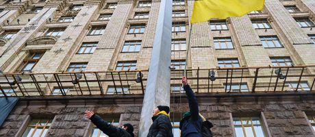 Activists hold Ukrainian flag during an action near the Kyiv City Council, demanding more money from the city budget for the Ukrainian armed forces