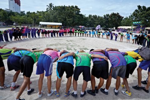 Sports team gathered in huddle at school sports event