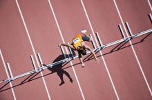Runner jumping hurdles on track