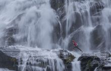 climber jumping between rocks under the "Cascata del Toce" (Toce waterfall), a waterfall in the Italian Alps climber jumping between rocks under the "Cascata del Toce" (Toce waterfall), a waterfall in the Italian Alps