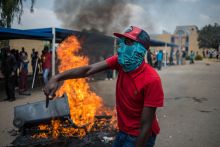 Students shout slogans next to a burning barricade during clashes with South African anti-riot police and campus security at a demonstration in support of the Fees Must Fall movement in 2016 Students shout slogans next to a burning barricade during clashes with South African anti-riot police and campus security at a demonstration in support of the Fees Must Fall movement in 2016