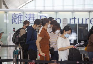 2022 Oct 2,Hong Kong.Passengers wearing masks line up at the check-in counter in the Hong Kong International Airport.