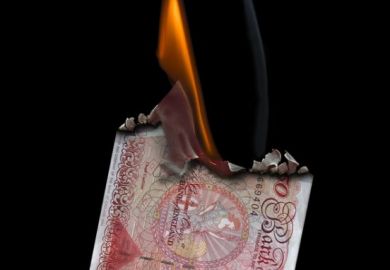 50 Pound Banknote on fire set on a black background.