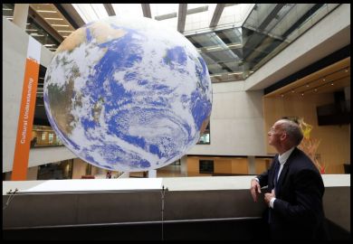 A man looks at a giant globe