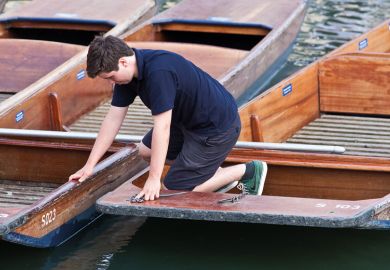 A boy working on the punts at the University of Cambridge A boy working on the punts at the University of Cambridge
