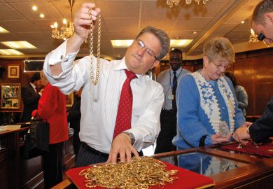 A man inspecting gold jewellery A man inspecting gold jewellery