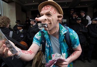 A protester wearing a greed mask holding fake money A protester wearing a greed mask holding fake money