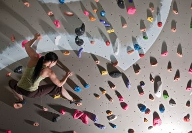 A woman scaling a climbing wall A woman scaling a climbing wall
