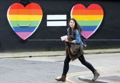 Woman walks past mural in favour of same-sex marriages