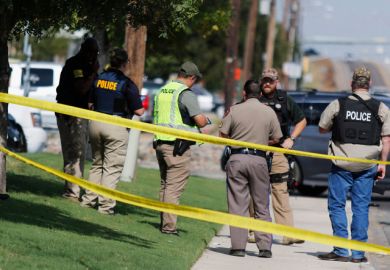 A law enforcement officer stands in the middle of the 5100 block of E. 42nd Street in Odessa, Texas, Saturday, Aug. 31, 2019, following a shooting at random in the area of Odessa and Midland. Several people were dead after a gunman who hijacked a postal s
