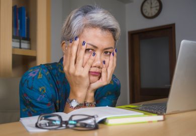 A woman reading a book with her head in her hands