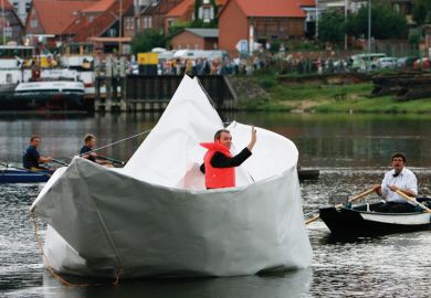 Artist Frank Boelter sitting in life-size paper boat Artist Frank Boelter sitting in life-size paper boat