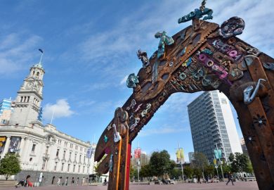 Auckland, New Zealand - August 10, 2015 People walk near a Traditional Maori entry gate at Aotea Square. Its one of the biggest squares in New Zealand used for open-air concerts, gatherings, markets and political rallies.