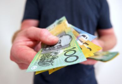 A man hands out Australian dollars
