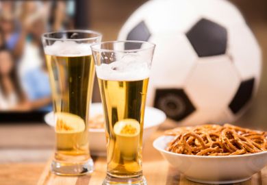 Beer, pretzels and football on pub table