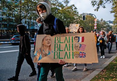 Person with placard with Greta Thunberg’s blah blah blah quote 