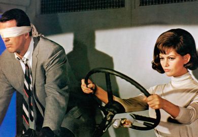 Film still from "Blindfold", showing man wearing a blindfold next to a woman driving, 1965. To illustrate a lack of supervision or monitoring during some remote assessments in UK universities 