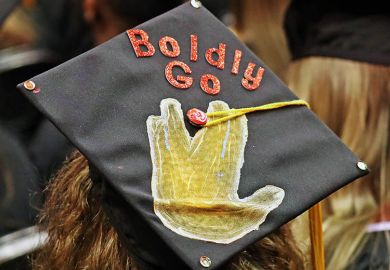 A mortarboard with 'Boldly Go' written on it during a graduation ceremony. To illustrate a new higher education provider that is offering master’s programmes taught by artificial intelligence.