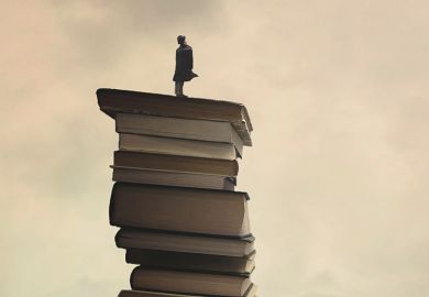 Person standing on tower of books