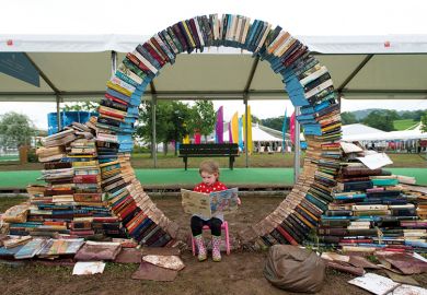 A girl reads a book during the Hay festival